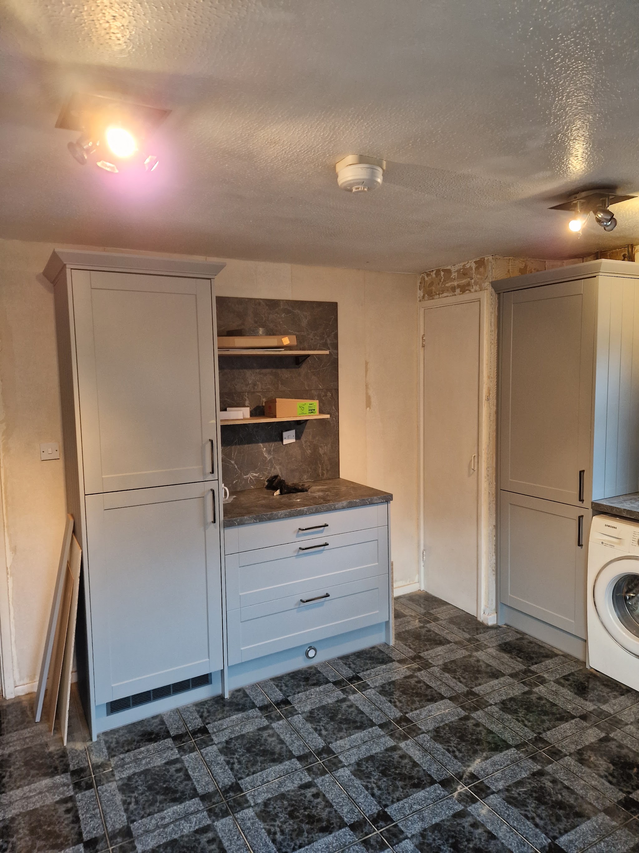 Tall shaker-style cupboards and a drawer unit fitted in a utility room