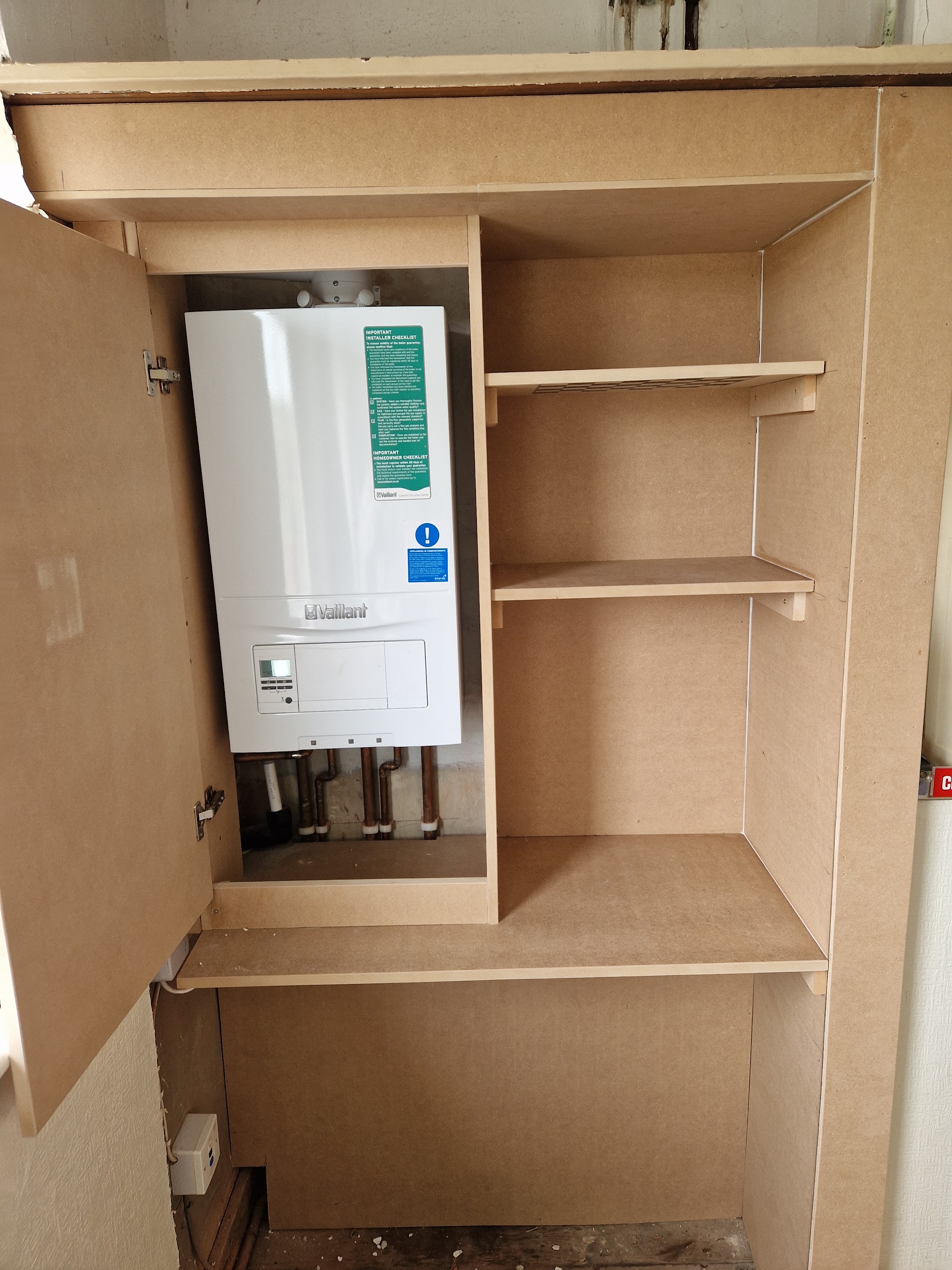 A boiler cupboard with adjustable shelving built around the boiler and pipework